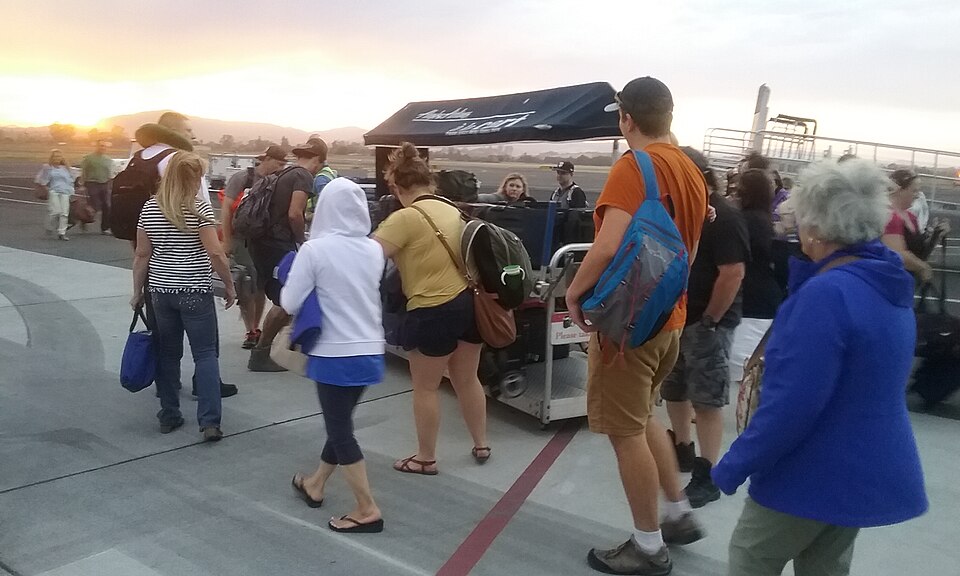 2017-09-11 STS passengers retreive luggage from a cart.jpg