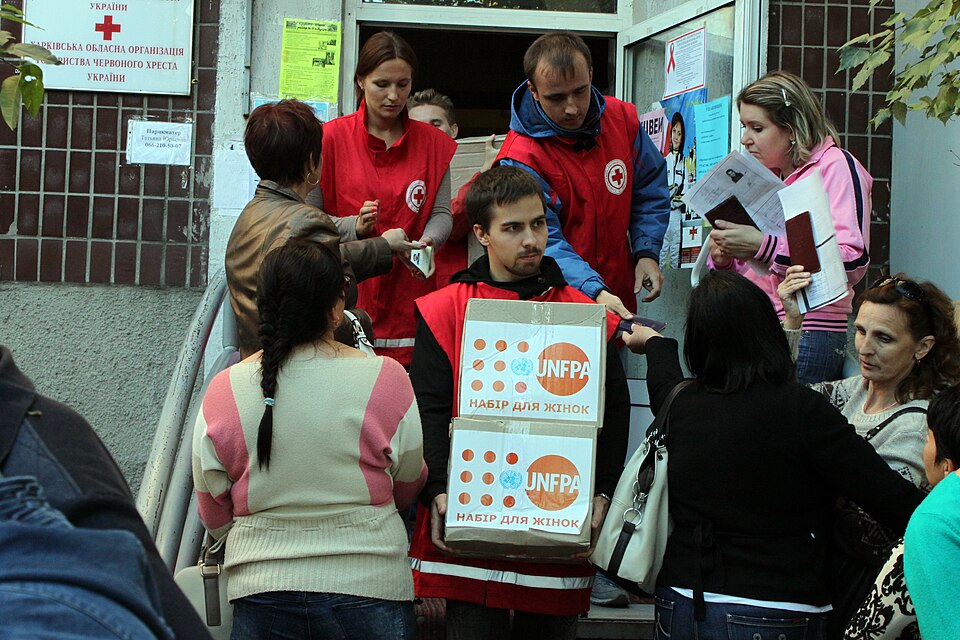 Red Cross volunteer with UNFPA humanitarian aid boxes (15286153495).jpg